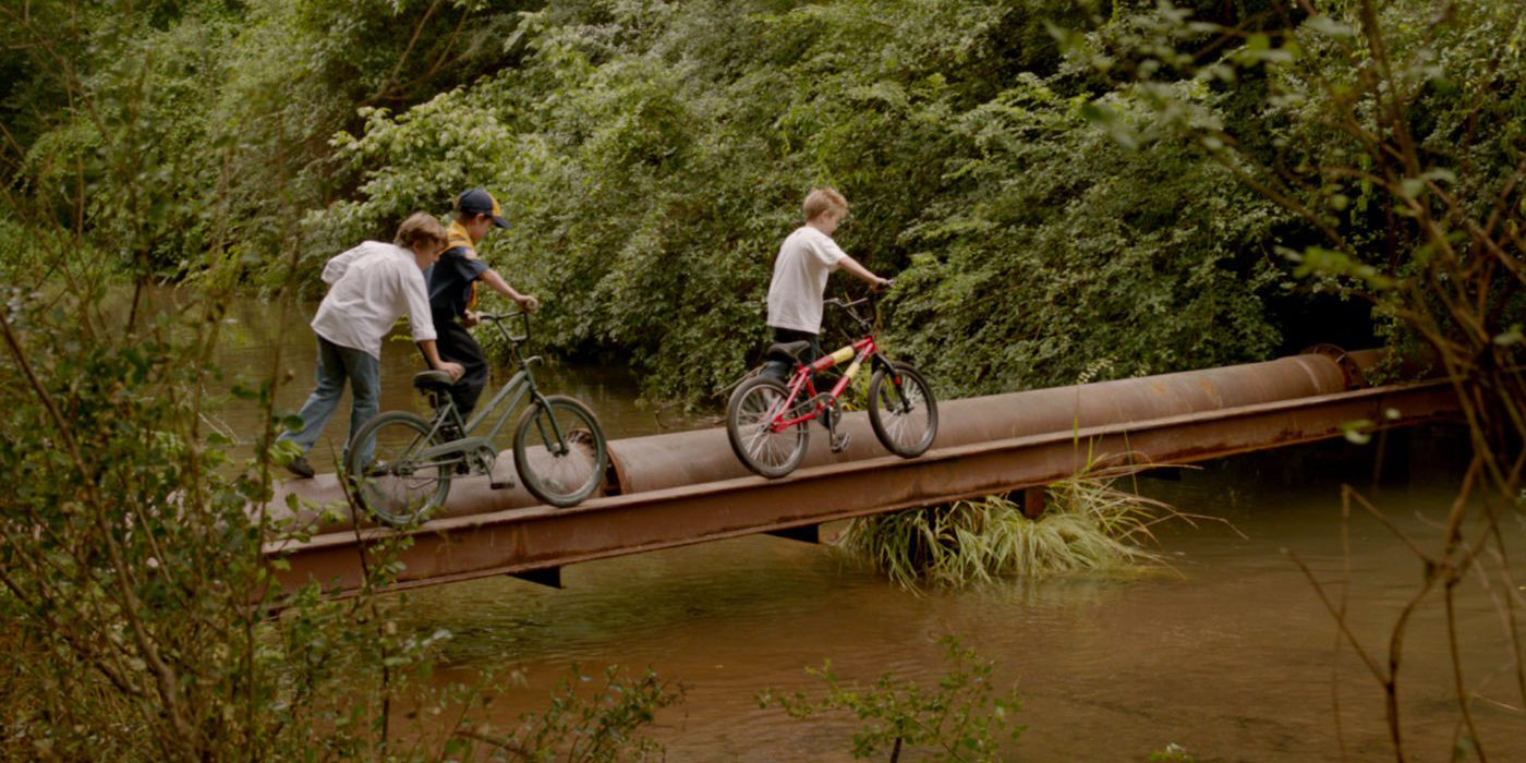 Trois enfants traversant un pont