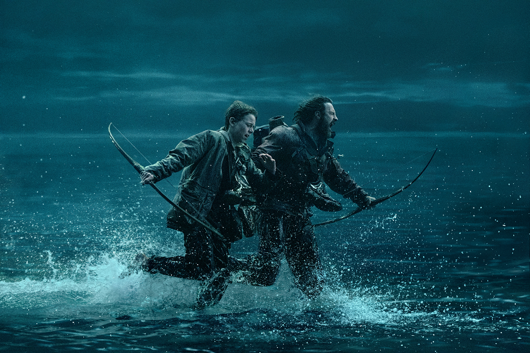 Jamie (Aaron Taylor-Johnson) and his son Spike (Alfie Williams) being chased on the causeway in Columbia Pictures' 28 YEARS LATER.