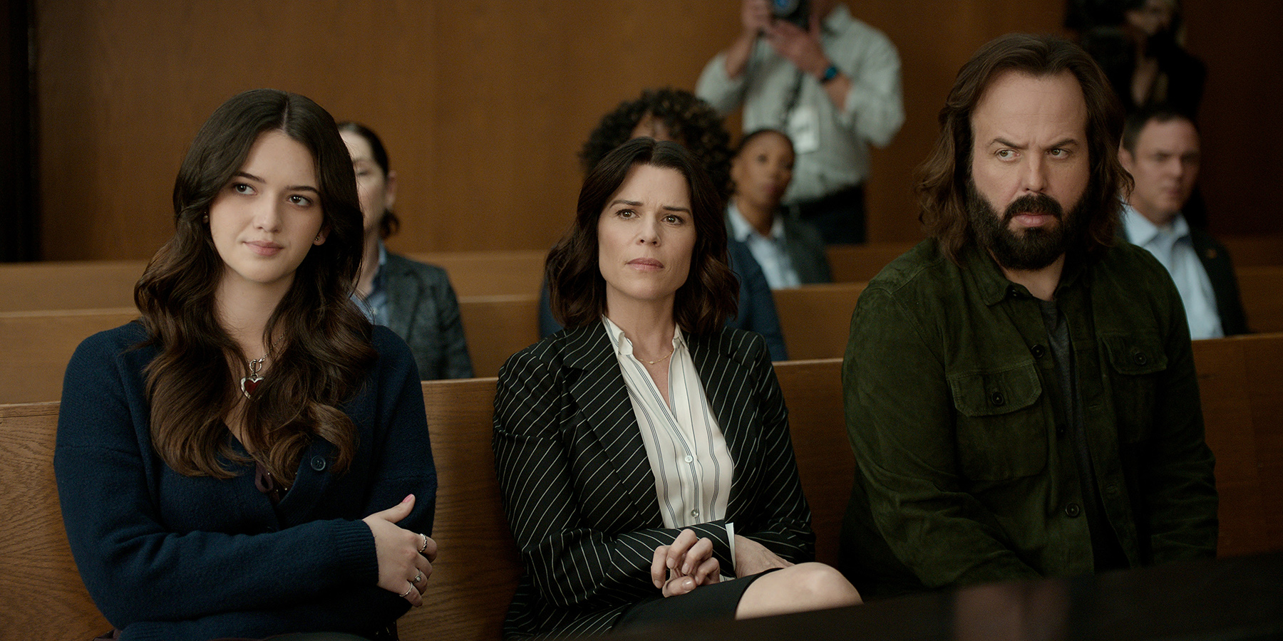 La Défense Lincoln. (De gauche à droite) Krista Warner (Hayley Haller), Neve Campbell (Maggie) et Angus Sampson (Denis « Cisco » Wojciechowski) dans l’épisode 402 de La Défense Lincoln. Crédit : Netflix © 2026